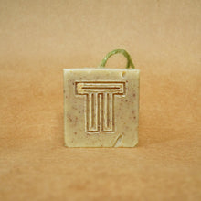 Load image into Gallery viewer, Moringa & Garden Greens Soap bar with unique logo, featuring natural ingredients on a brown background.