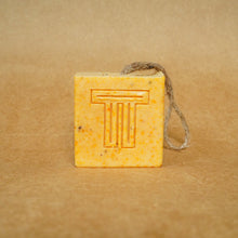 Load image into Gallery viewer, Dragon Fruit, Papaya & Carrot Soap cube with natural fibers on a brown background.