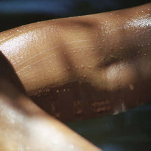 Load image into Gallery viewer, Coriander Seed Omega Body Oil moisturizing skin with hydration and glow on a smooth arm.