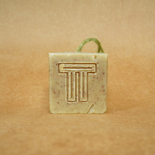 Moringa & Garden Greens Soap bar with unique logo, featuring natural ingredients on a brown background.